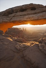 Sun shining behind Mesa Arch, Canyonlands National Park, Utah.