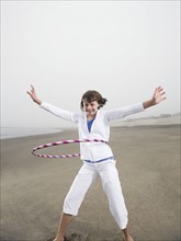 Portrait of girl with hula hoop on beach. Date : 2008
