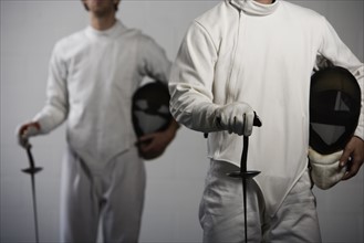 Portrait of fencers holding masks and fencing foils. Date: 2008