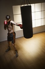 Boxer training with punching bag. Date: 2008