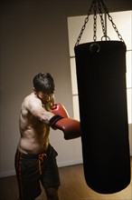 Boxer training with punching bag. Date: 2008