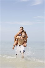 Couple splashing in ocean surf. Date: 2008