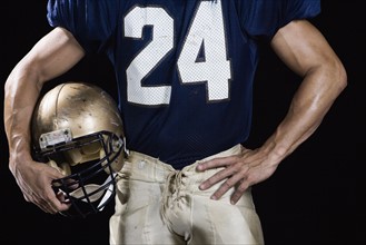 Football player wearing uniform and holding helmet. Date : 2008