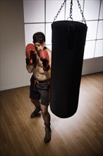Boxer training with punching bag. Date : 2008