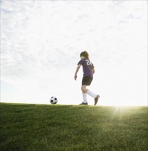 Boy in uniform kicking soccer ball. Date: 2008