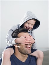 Close up of boy covering father’s eyes. Date : 2008