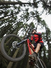 Mountain biker in mid-air in forest. Date : 2008