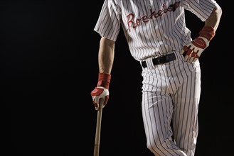 Midsection portrait of baseball player leaning on bat. Date : 2008