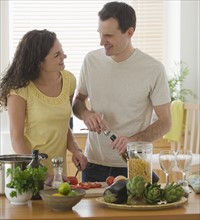 Couple preparing meal in kitchen.