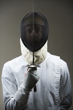 Portrait of fencer in uniform and mask holding fencing foil. Date : 2008