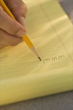 Man writing “www” on legal pad.