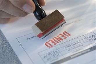 Man stamping “denied” on mortgage application.
