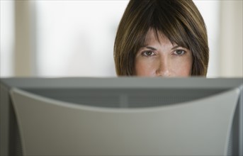 Close up of woman looking at computer monitor.
