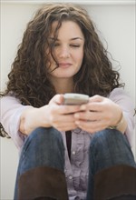 Woman text messaging on cell phone.