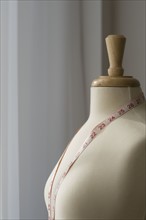 Measuring tape on dressmakers model.