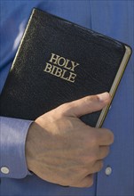 Man holding Holy Bible.
