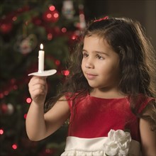 Girl holding Christmas candle.