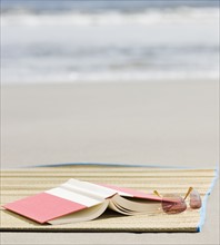 Book and sunglasses on beach. Photographe : Jamie Grill