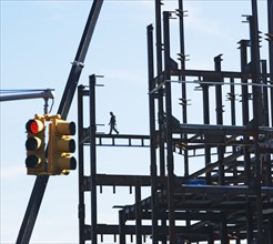 Construction worker walking on beams. Photographe : fotog