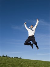 Businessman jumping in air.