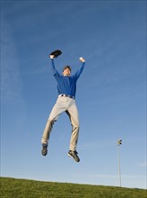 Baseball player jumping in air.