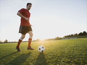 Soccer player dribbling ball.