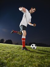 Soccer player kicking ball.