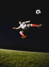 Soccer player kicking ball.