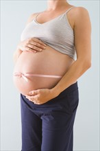 Pregnant woman’s belly wrapped in pink ribbon. Photographe : Jennifer L. Boggs