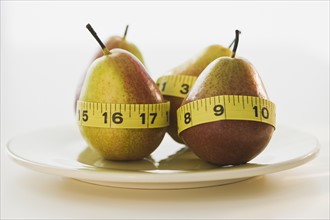 Pears wrapped in tape measures. Photographe : Daniel Grill