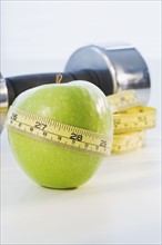 Apple wrapped in tape measure. Photographe : Daniel Grill