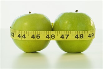 Apples wrapped in tape measure. Photographe : Daniel Grill