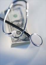 Stack of money and stethoscope.
