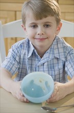 Boy showing empty bowl.