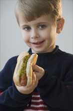 Boy eating hot dog.