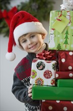 Boy posing with Christmas gifts.