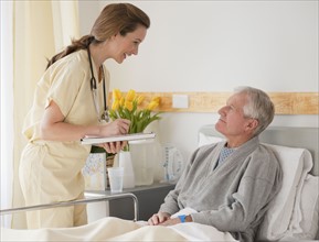 Nurse caring for senior man in hospital.