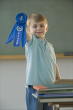 Boy holding first place ribbon.