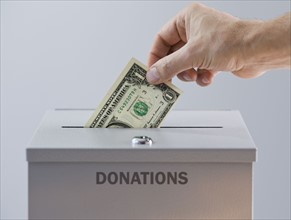 Man placing money in donation box.