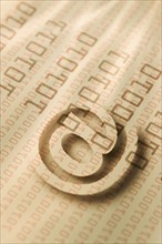 Close up of “at’ symbol and binary code.