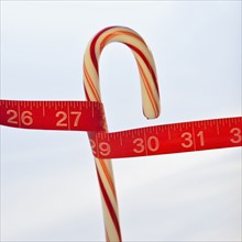 Measuring tape around candy cane.