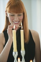 Woman lighting holiday candles.