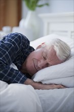 Senior man sleeping in bed.