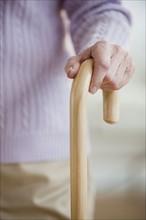 Close up of senior woman holding cane.