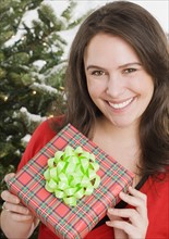 Woman holding Christmas gift. Photographe : Jamie Grill