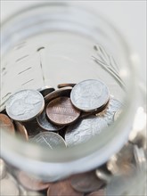 Coins in savings jar. Photographe : Jamie Grill