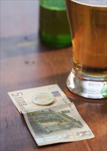 Close up of beer and money. Photographe : Jamie Grill