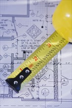 Close up of blueprint and tape measure. Photographe : Daniel Grill