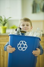 Boy carrying full recycling bin. Photographe : Daniel Grill