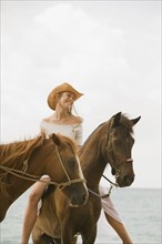 Woman riding horse on beach. Photographe : mark edward atkinson
